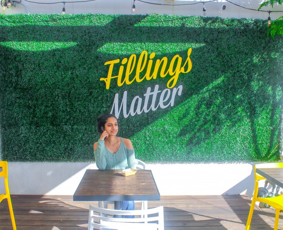 This is a snap of the famous Fillings Matter wall in Bishop Arts District. The wall is located at Picole Pops. It's a textured green with the word filling written in yellow. 