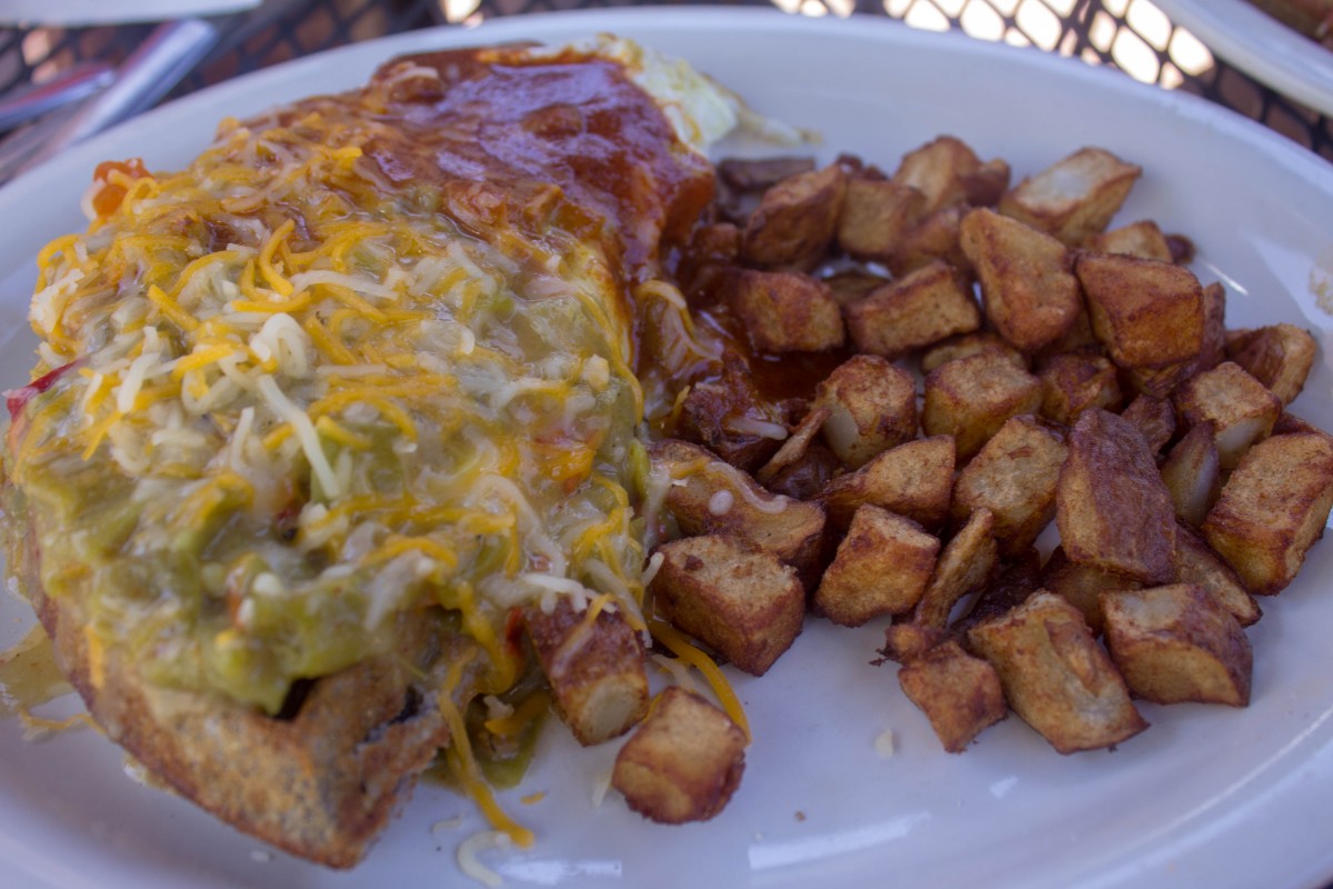 blue corn waffles slathered in red and green chile and a side of potatoes is a traditional New Mexican breakfast