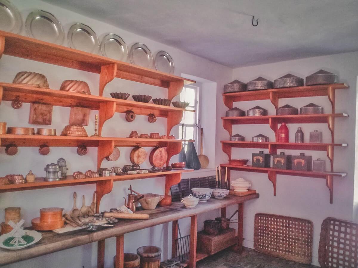 Shelves of plates and pans and cooking utensils line this building in Colonial Williamsburg. 