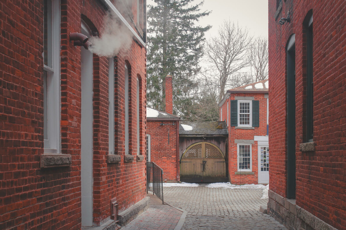 photo of a small town alley in Connecticut that looks quintessentially New England with its brick buildings and frosty atmosphere