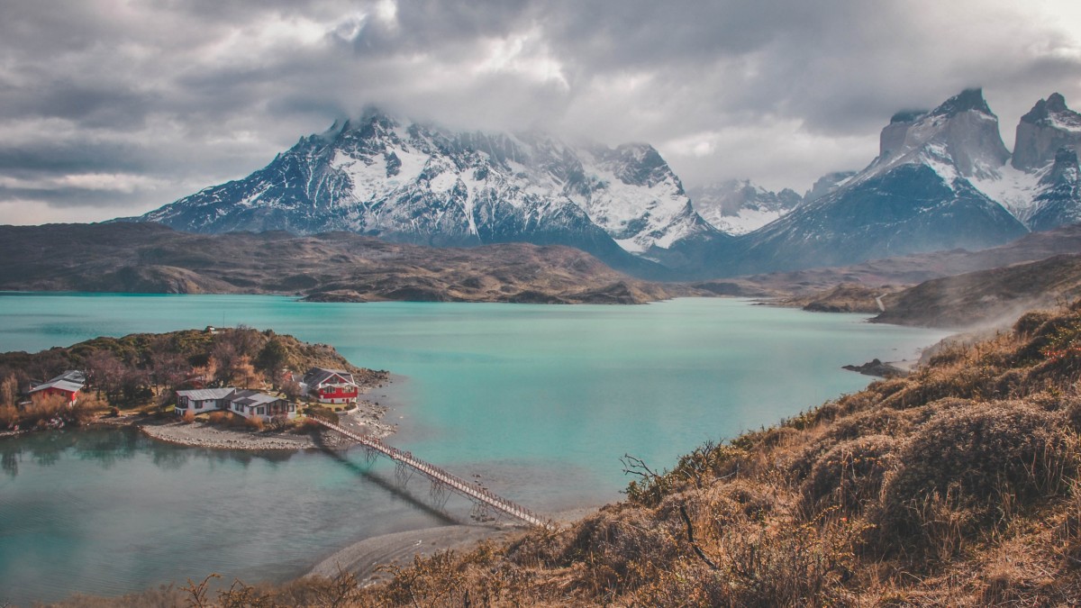 aqua blue waters of Patagonia with a view of Paine Massif covered by fog