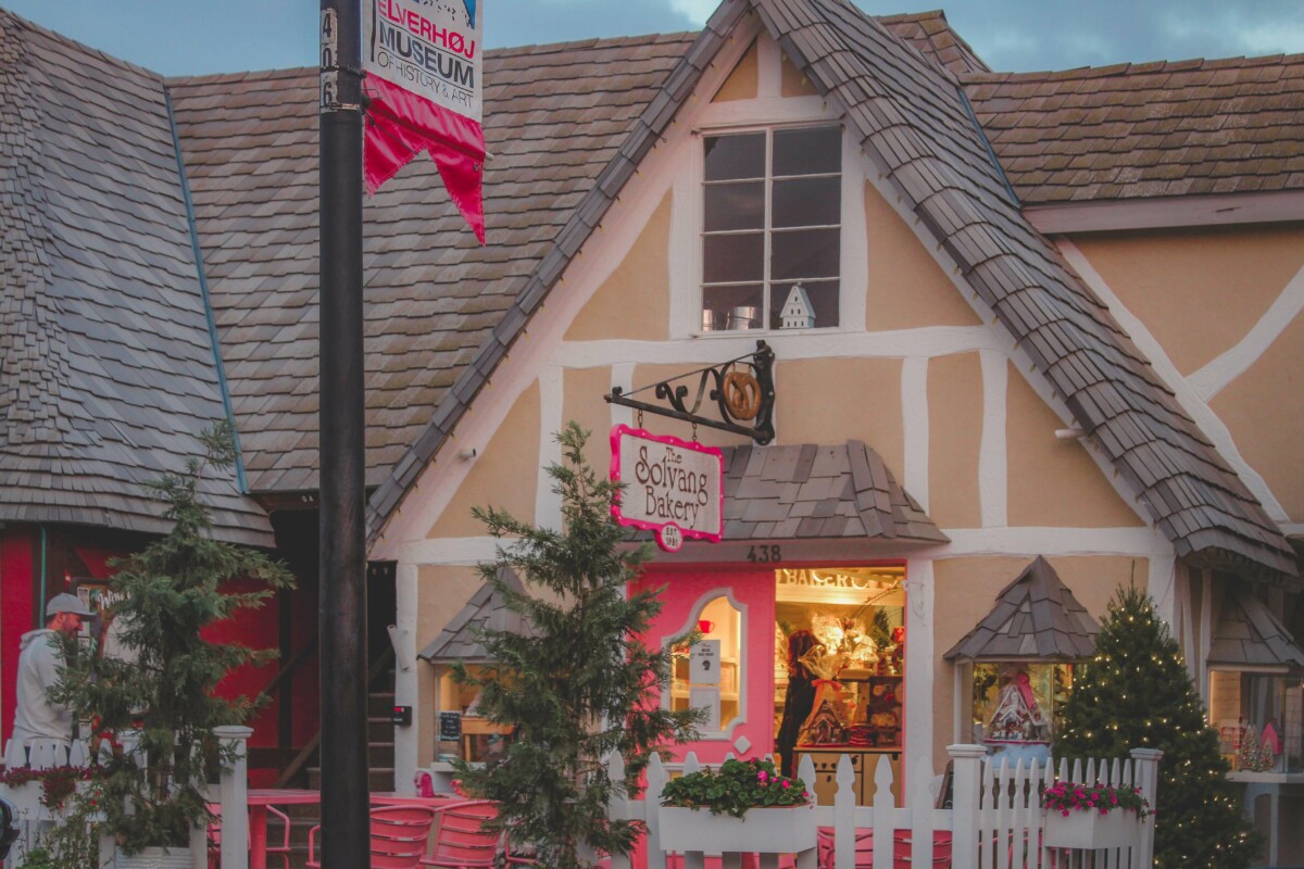 The Solvang Bakery pink sign and pink door and pink chairs outside
