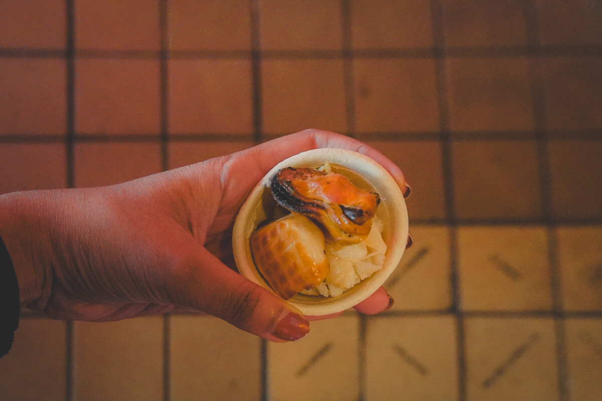 holding a sample of three different types of seafood you can find at Pike Place Market